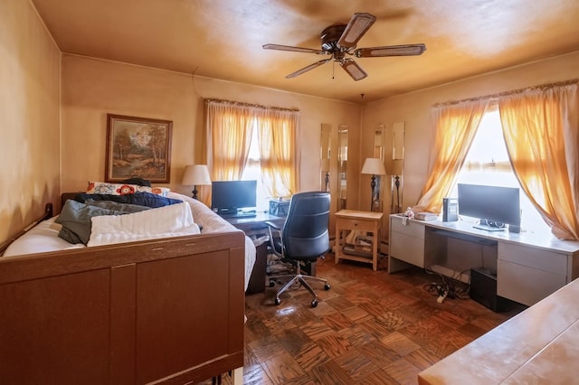 office area with ceiling fan and dark parquet flooring