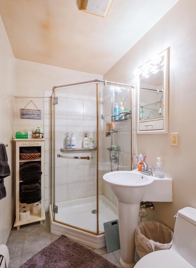 bathroom with an enclosed shower, tile patterned floors, and toilet