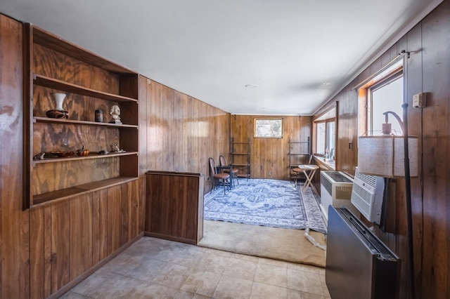 carpeted living room featuring wooden walls and built in features