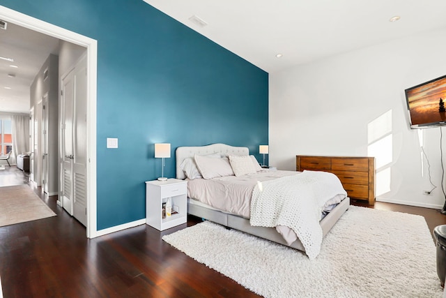 bedroom with dark hardwood / wood-style flooring