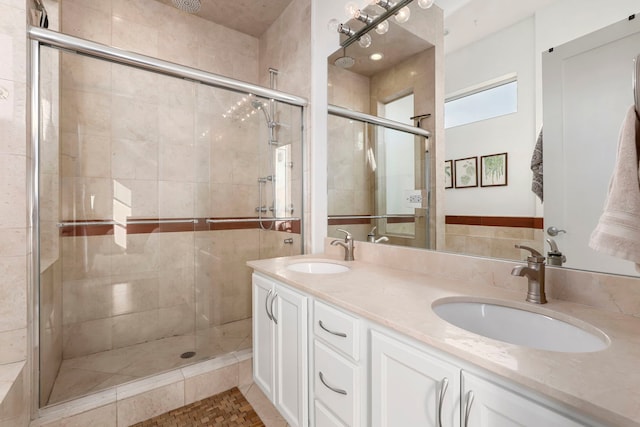 bathroom featuring a shower with shower door and vanity