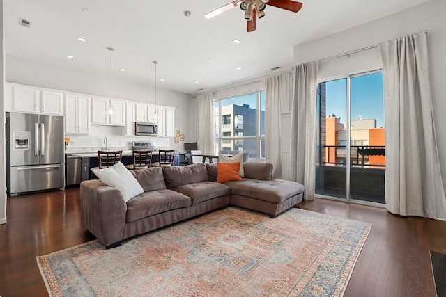 living room with ceiling fan and dark hardwood / wood-style floors