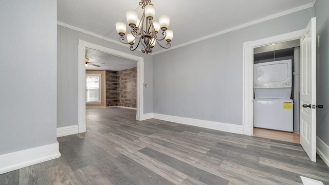 unfurnished dining area featuring hardwood / wood-style flooring, crown molding, and stacked washer and clothes dryer