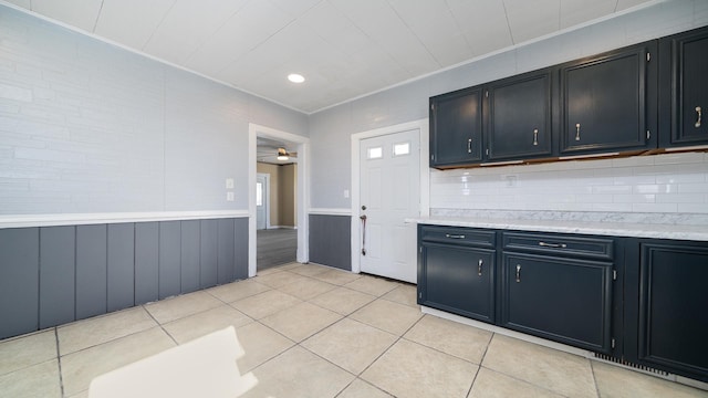 kitchen featuring ceiling fan, ornamental molding, decorative backsplash, and light tile patterned floors