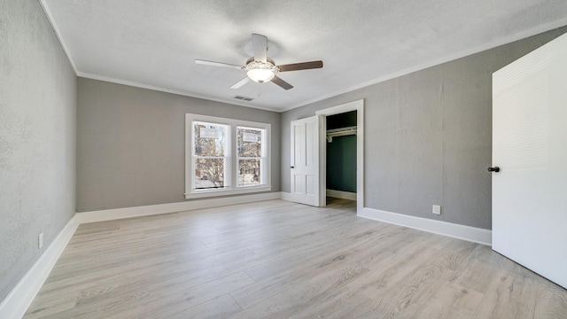 unfurnished bedroom featuring crown molding, a textured ceiling, ceiling fan, and light hardwood / wood-style flooring