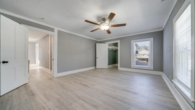 unfurnished bedroom with crown molding, a textured ceiling, a closet, ceiling fan, and light hardwood / wood-style floors