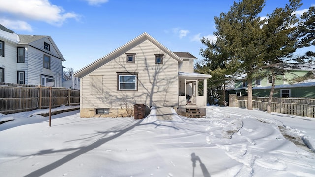 view of snow covered back of property