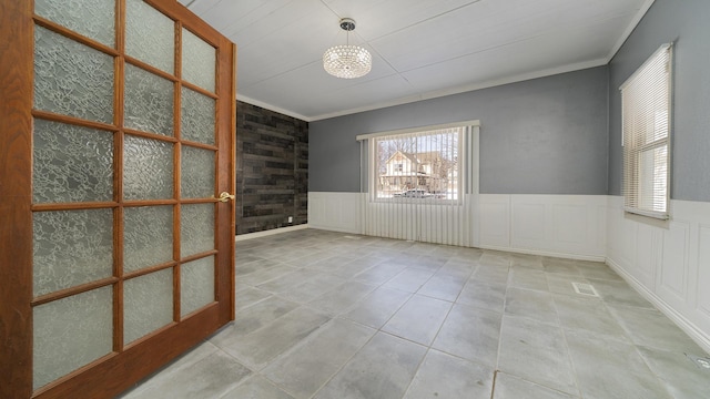 unfurnished room featuring light tile patterned floors and crown molding