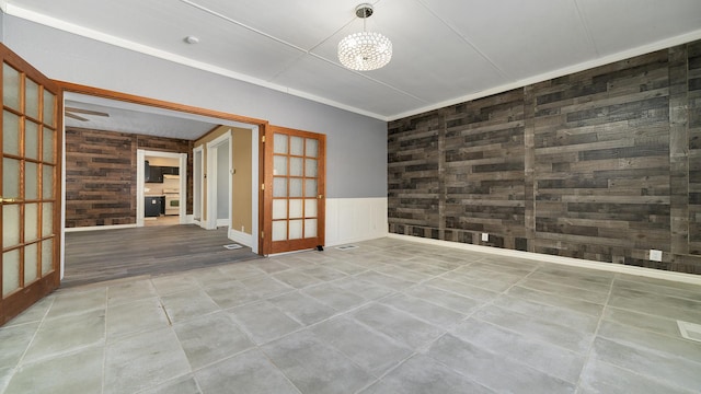 empty room featuring light tile patterned floors, an inviting chandelier, and french doors