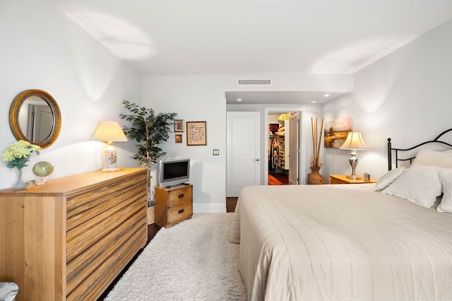 bedroom featuring carpet, a walk in closet, visible vents, and baseboards