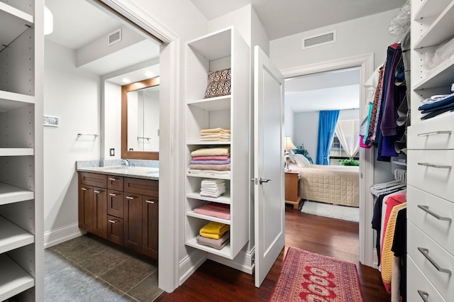 ensuite bathroom with ensuite bath, visible vents, wood finished floors, and vanity