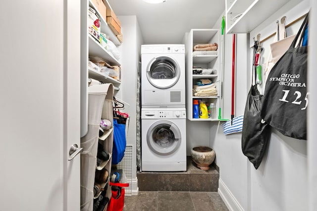 laundry area with stacked washer and clothes dryer, baseboards, and laundry area