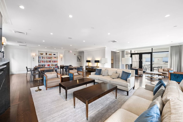 living area with visible vents, wood-type flooring, crown molding, a fireplace, and recessed lighting