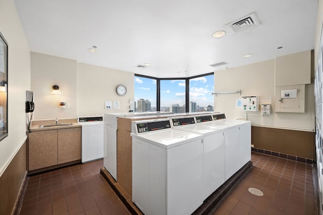 common laundry area featuring recessed lighting, a sink, visible vents, washer and dryer, and a view of city