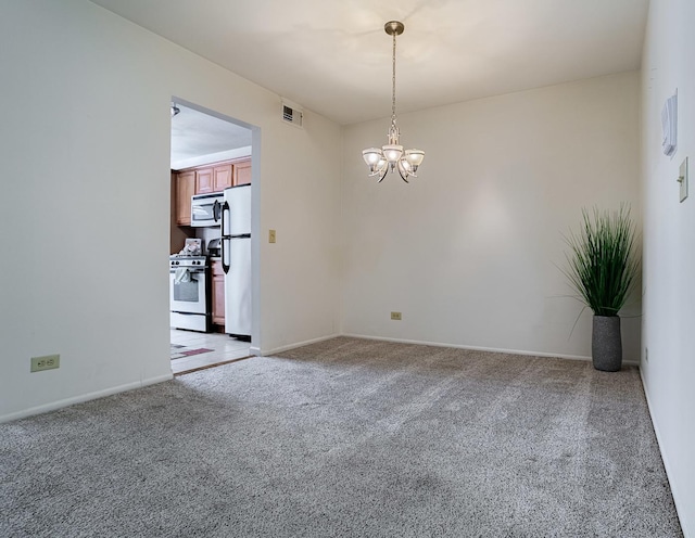 carpeted empty room featuring a chandelier