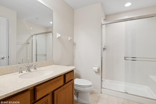 bathroom with toilet, vanity, tile patterned floors, and a shower with shower door