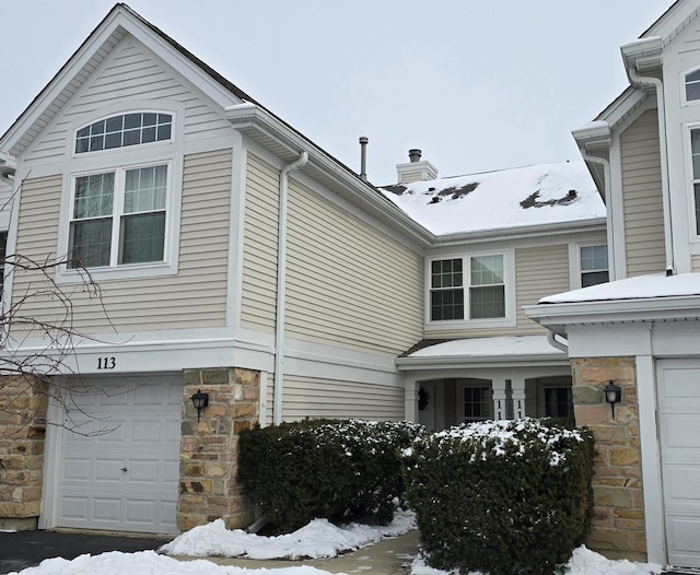 view of snowy exterior featuring a garage