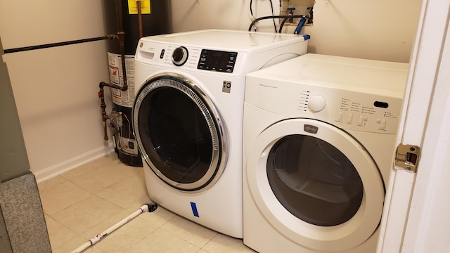 laundry room featuring light tile patterned floors, washer and clothes dryer, and water heater