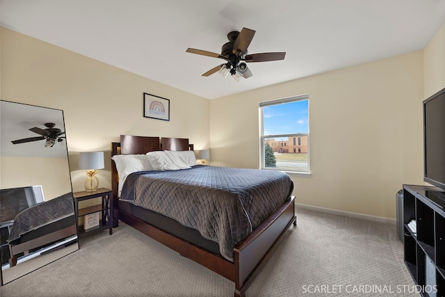 carpeted bedroom with ceiling fan and baseboards