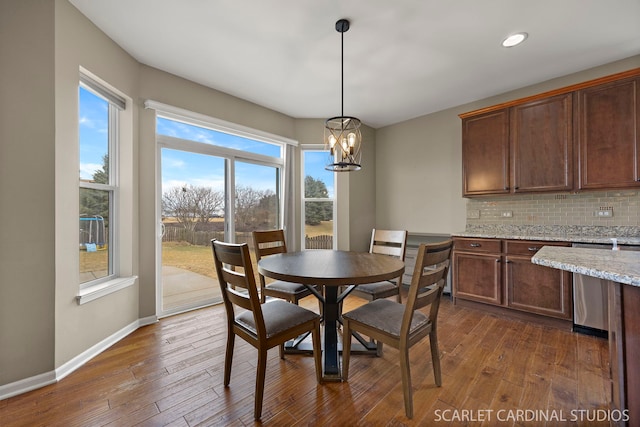 dining space with dark wood-style floors, recessed lighting, a chandelier, and baseboards