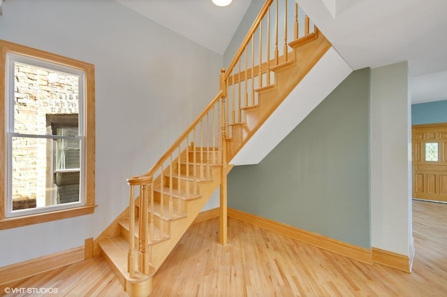 staircase featuring lofted ceiling and hardwood / wood-style floors