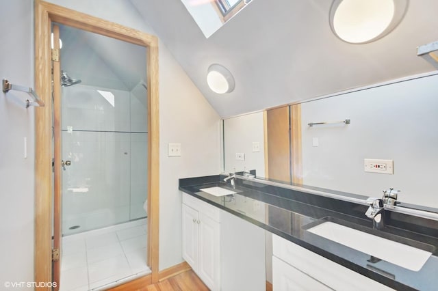 bathroom featuring a shower with door, lofted ceiling with skylight, and vanity