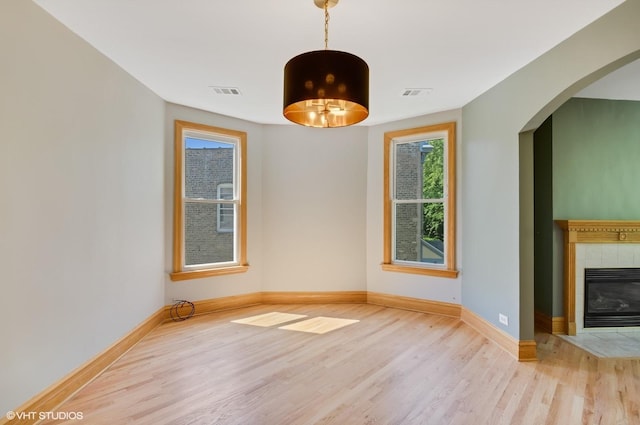 interior space with light hardwood / wood-style flooring and a tile fireplace