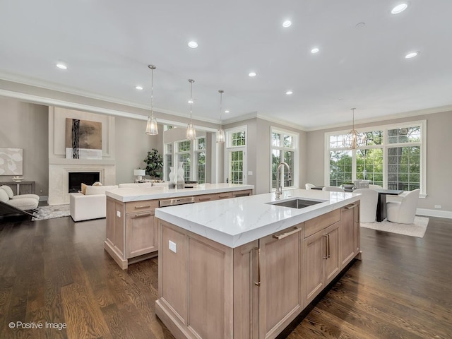 kitchen featuring light brown cabinetry, decorative light fixtures, sink, a large island, and crown molding