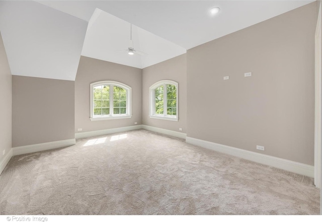 carpeted spare room featuring lofted ceiling and ceiling fan