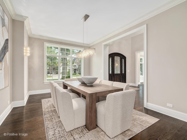 dining area featuring dark hardwood / wood-style flooring, a notable chandelier, and ornamental molding