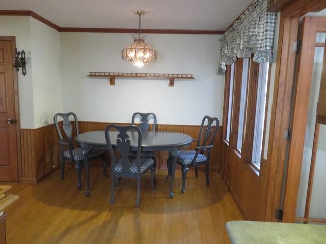 7623 288th Ave, Salem, WI 53168 - dining area featuring wood-type flooring, crown molding, a chandelier, and wooden walls