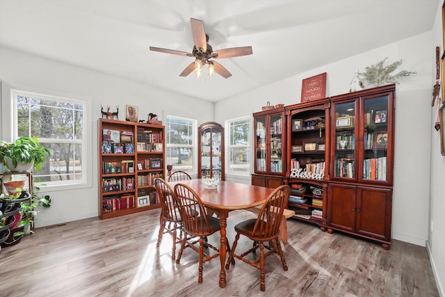 dining space with light hardwood / wood-style floors and ceiling fan