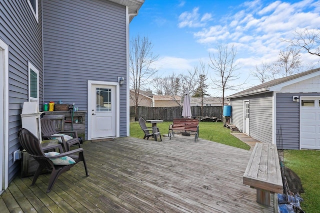 wooden terrace featuring a yard and an outbuilding