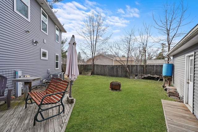 view of yard with cooling unit, a deck, and a fire pit