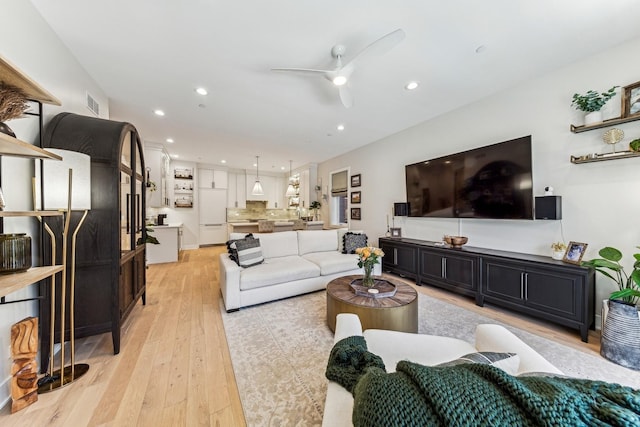 living area with light wood-style flooring, visible vents, ceiling fan, and recessed lighting