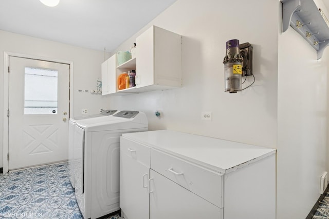 clothes washing area with washing machine and dryer and cabinet space