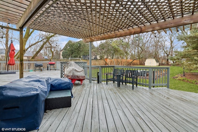 wooden terrace featuring a storage shed, an outdoor structure, a fenced backyard, and a pergola