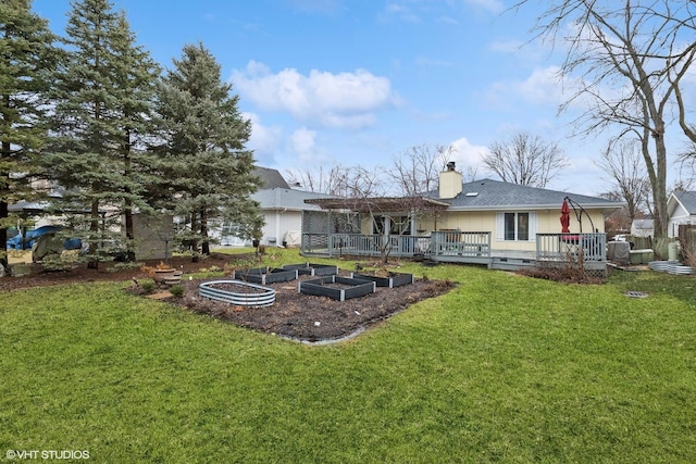 rear view of property featuring a garden, a lawn, a chimney, crawl space, and a wooden deck