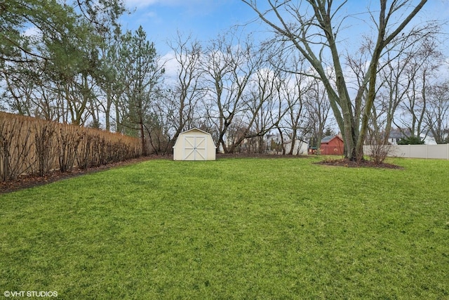 view of yard with fence, a storage unit, and an outdoor structure