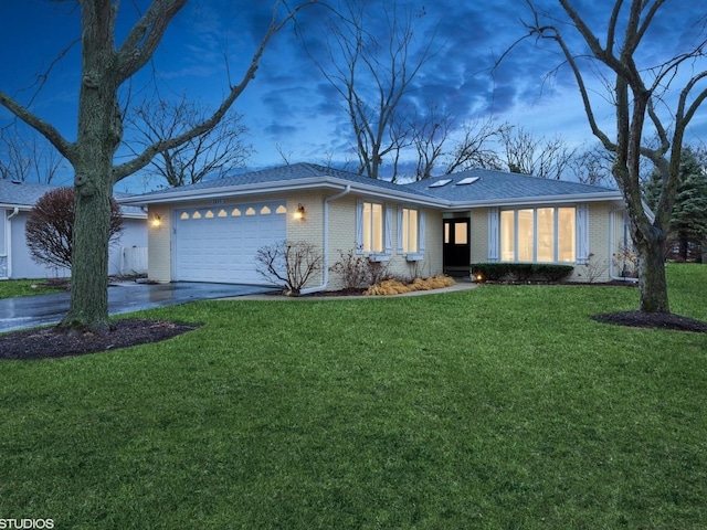 ranch-style home featuring a front yard, brick siding, driveway, and an attached garage