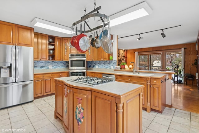 kitchen with a center island, open shelves, stainless steel appliances, light countertops, and light tile patterned flooring