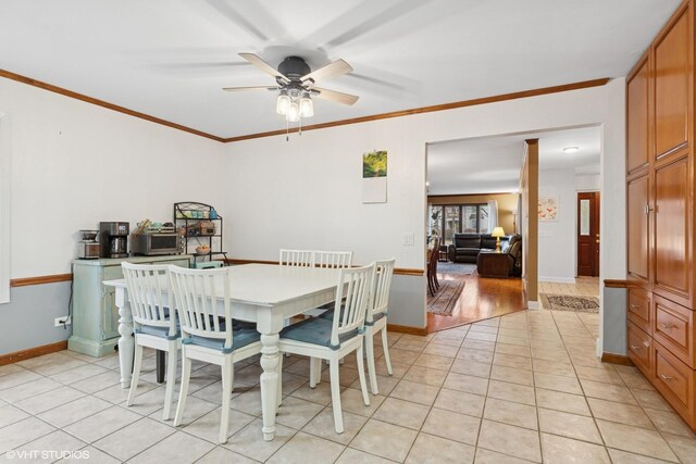 dining room featuring light tile patterned floors, baseboards, and crown molding