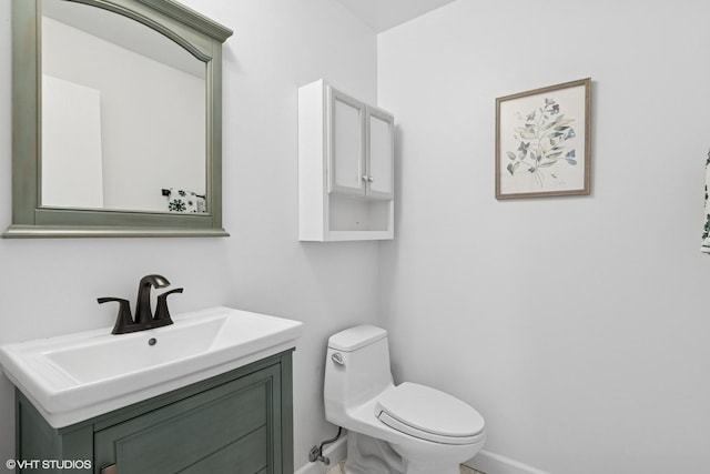 bathroom featuring vanity, toilet, and baseboards