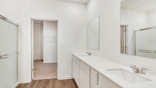 bathroom with vanity, hardwood / wood-style floors, and walk in shower