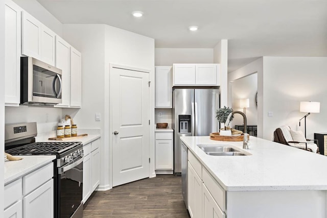 kitchen with sink, dark wood-type flooring, appliances with stainless steel finishes, an island with sink, and white cabinets