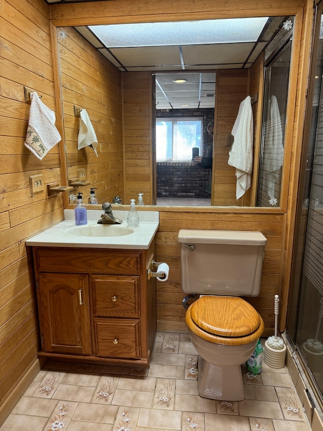 bathroom featuring vanity, toilet, and wood walls