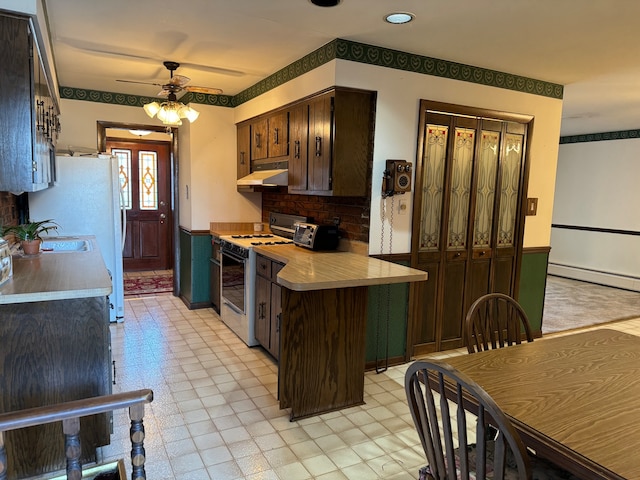 kitchen with a baseboard heating unit, ceiling fan, kitchen peninsula, dark brown cabinets, and white appliances