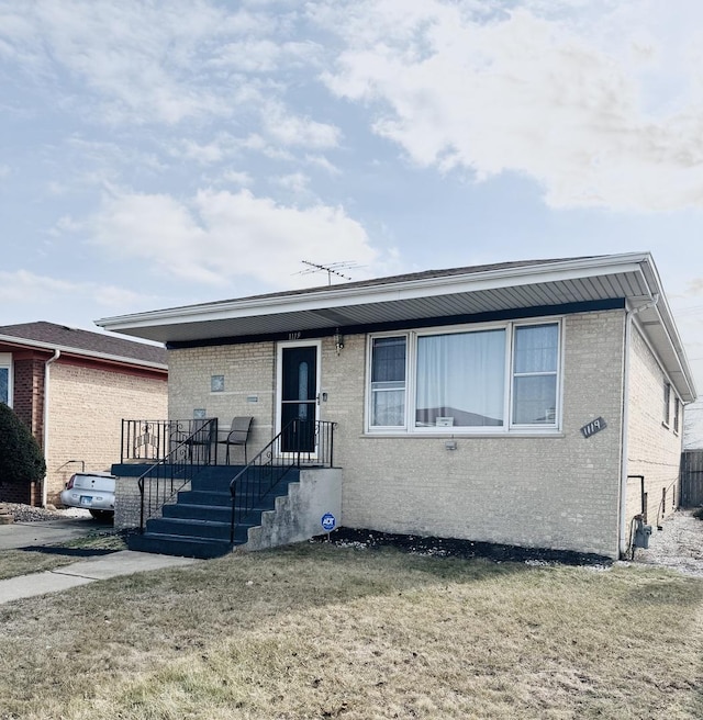 view of front of property featuring brick siding and a front lawn