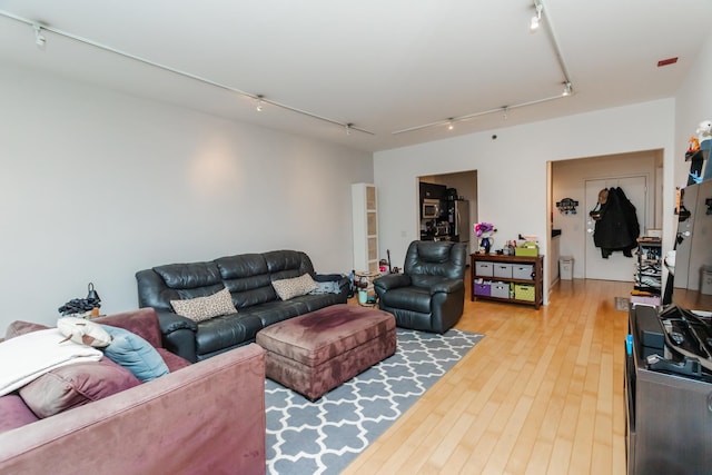 living room with track lighting and light hardwood / wood-style floors