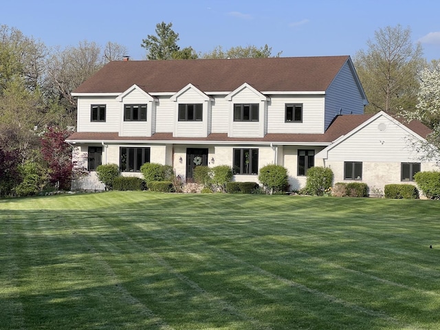 view of front of home with a front yard and roof with shingles